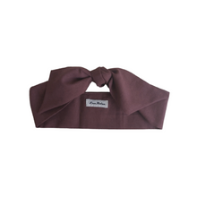 Load image into Gallery viewer, Dark brown headband with a brand label on a white background