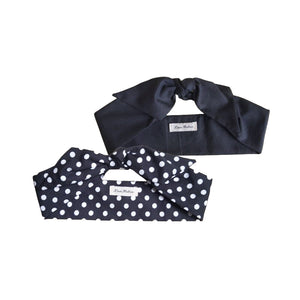 Two hair scarves laid out on a white surface, one solid black and the other with a black and white polka dot pattern.