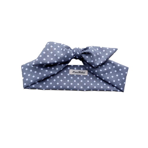 A grey polka dot hair scarf displayed on a hanger against a white background.