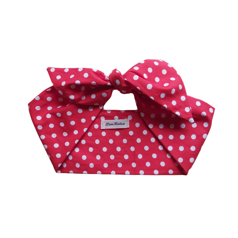Red polka dot headband with a large bow on a white background