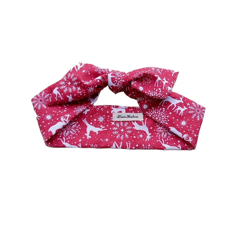 A red and white reindeer print hair scarf laid flat on a surface.