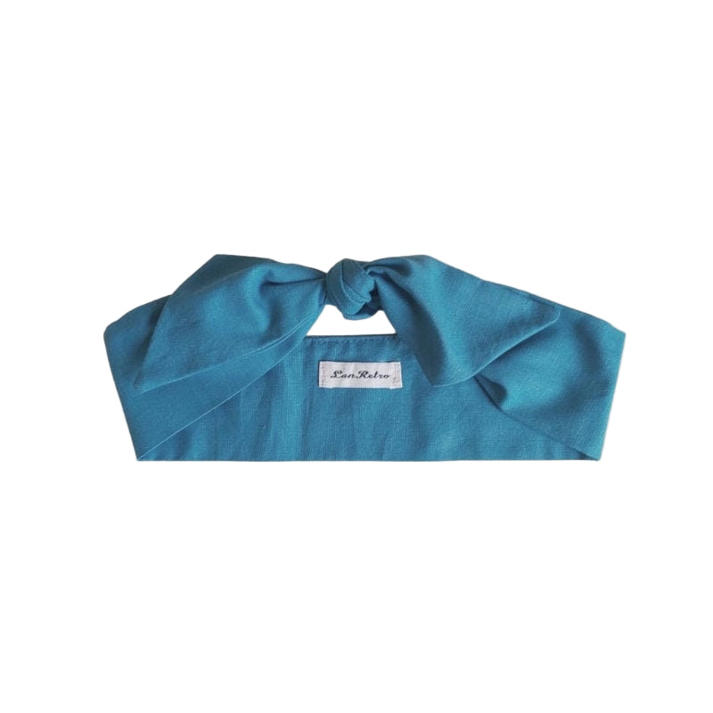 Teal blue scarf with a brand label on a white background