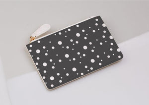 grey and white dotty coin purse on a light grey background