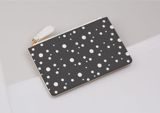 grey and white dotty coin purse on a light grey background