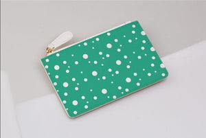 Jade and white dotty print coin purse on a light grey background