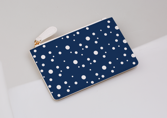 navy and white dotty coin purse on a light grey background